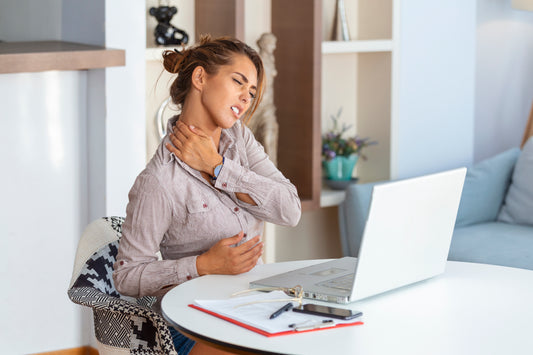 woman working in an office with upper back pain