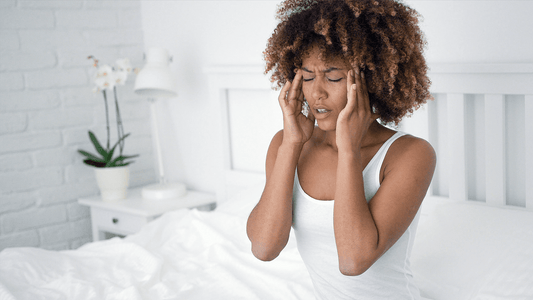 A woman rubbing her temples attempting to relieve a migraine